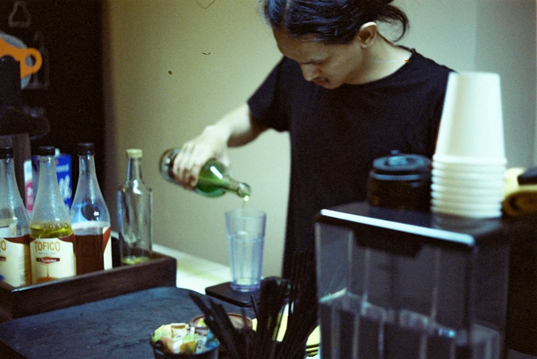 a woman is putting some ingredients in a glass