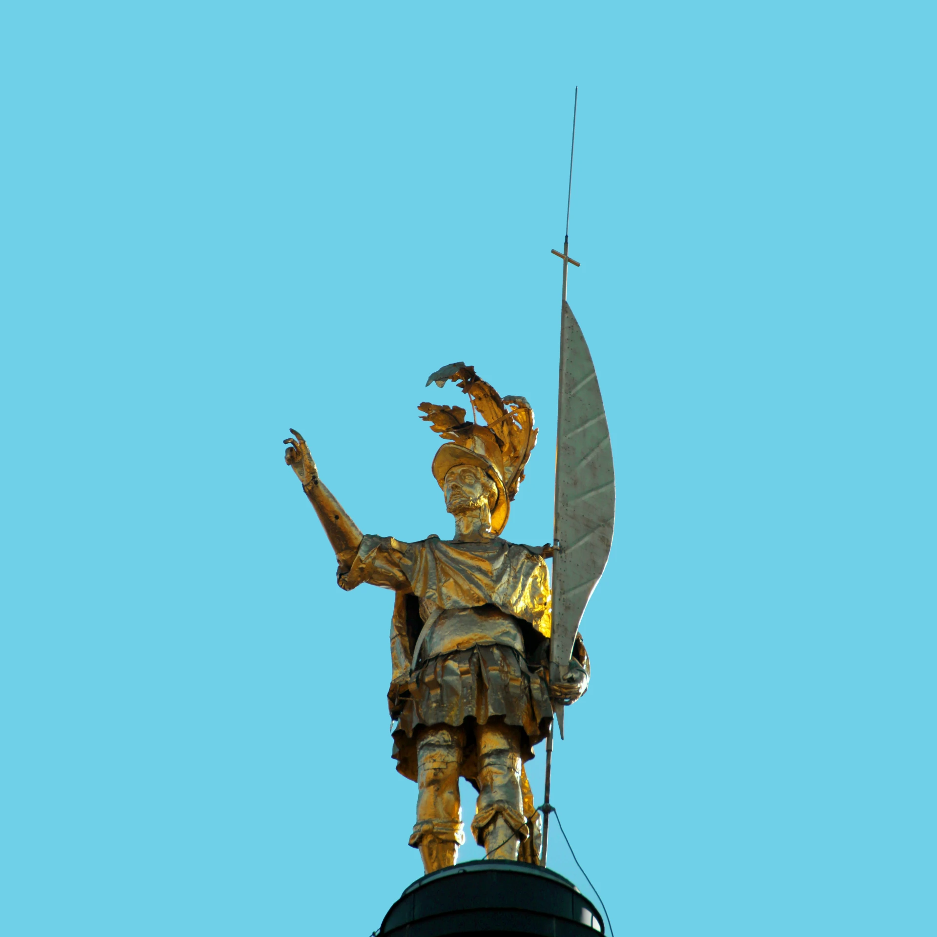 statue on top of a building with an antenna and flag