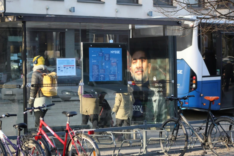 three bikes and a bicycle stand in front of a bus