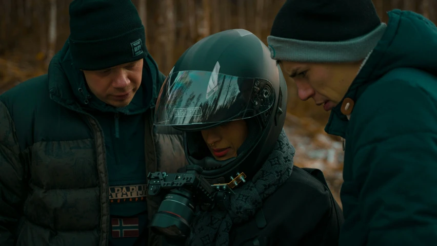 a man standing next to a woman wearing a helmet