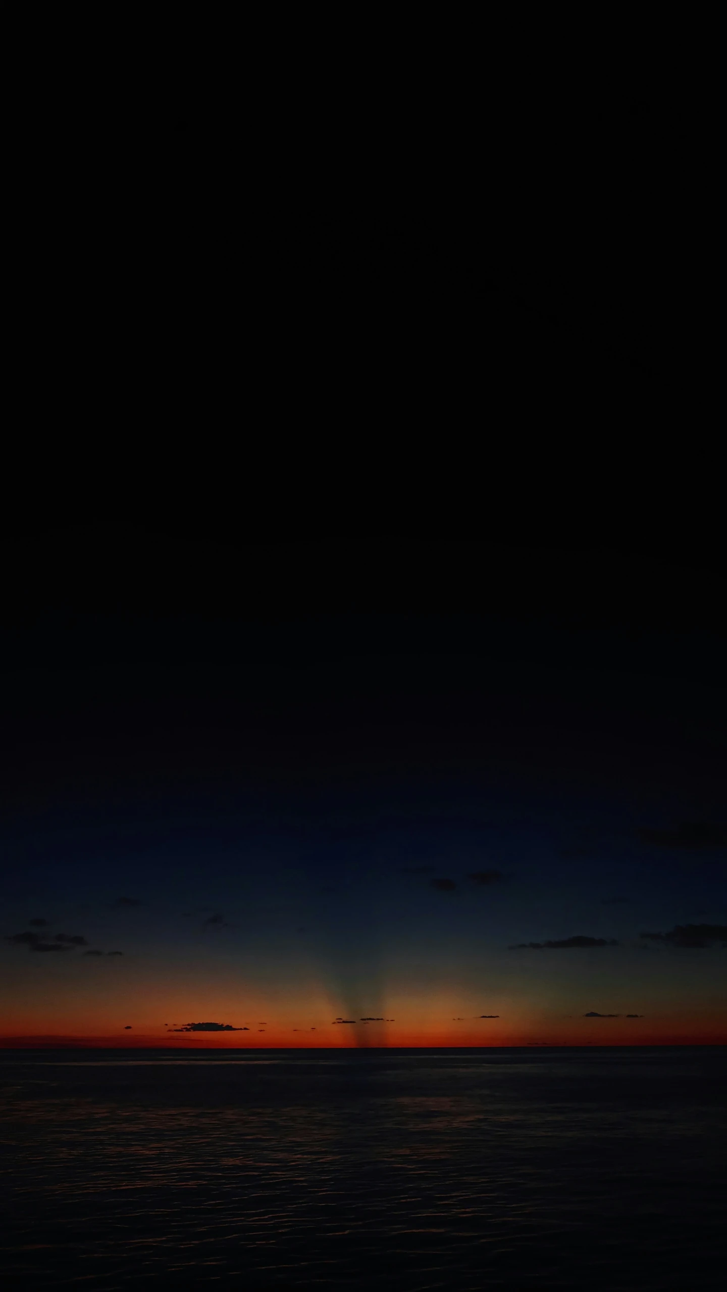 a jet airplane flying over the ocean at sunset