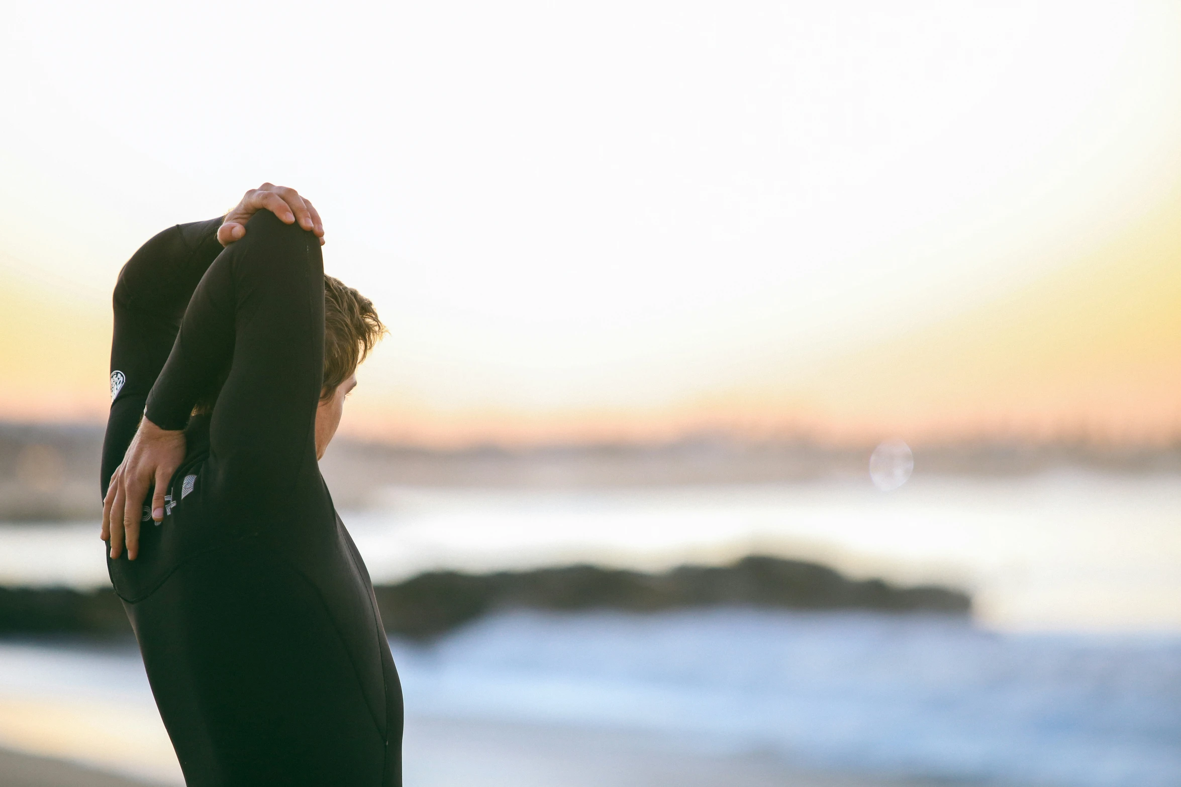 a person is standing on the beach with his back turned to one side