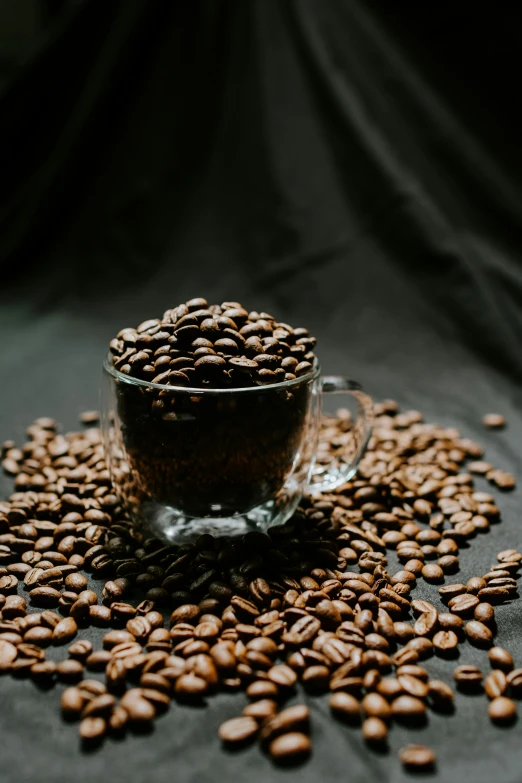 a cup of coffee beans sits on top of the table