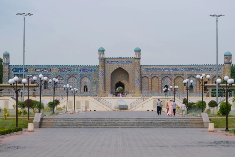 people standing at the top of stairs in front of an elaborate building