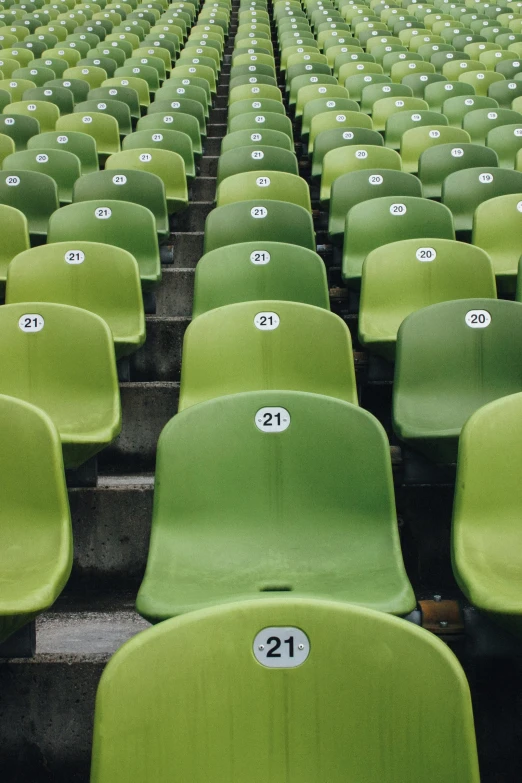 rows of green plastic seats with numbers on them