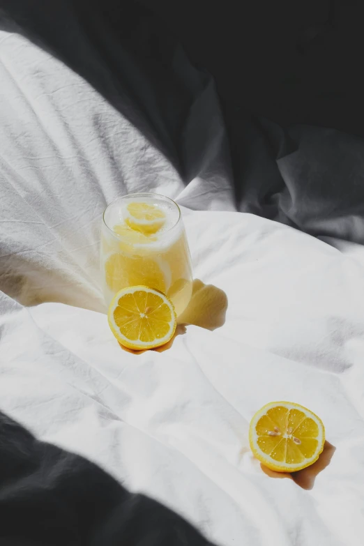 a glass with some lemons next to it