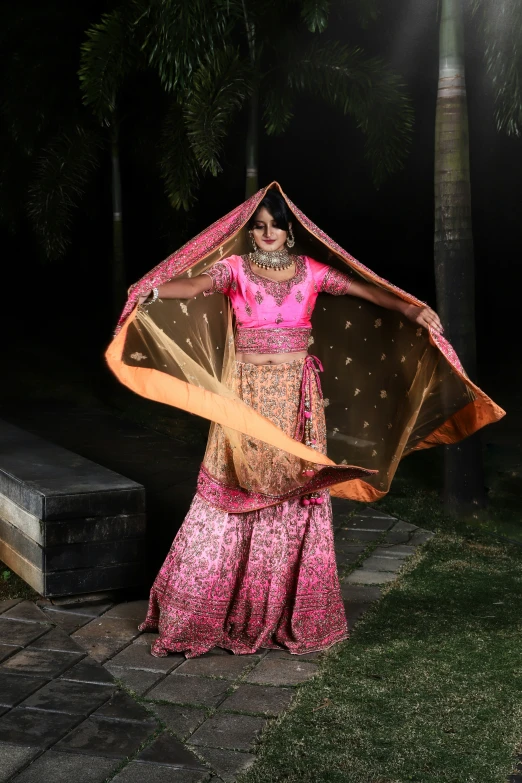 a woman is wearing a large pink frock and a shawl