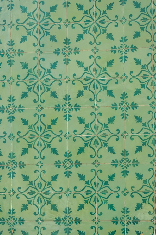 a green tiled wall with vines and swirls