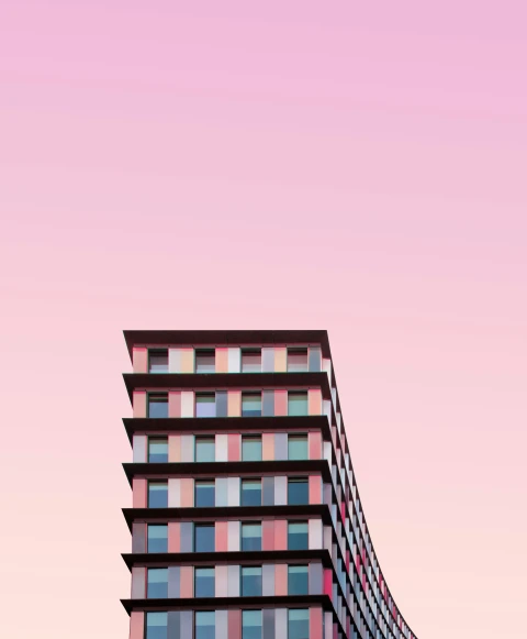 colorful building with large windows against a pink sky