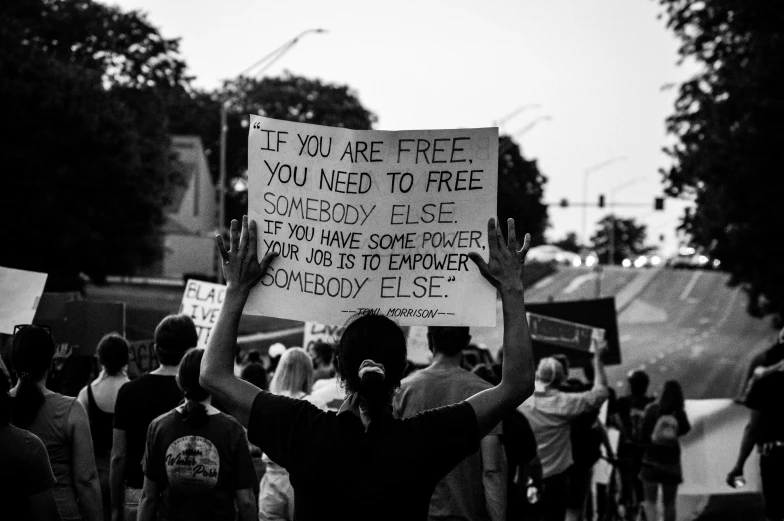 people carrying protest signs while marching through the streets