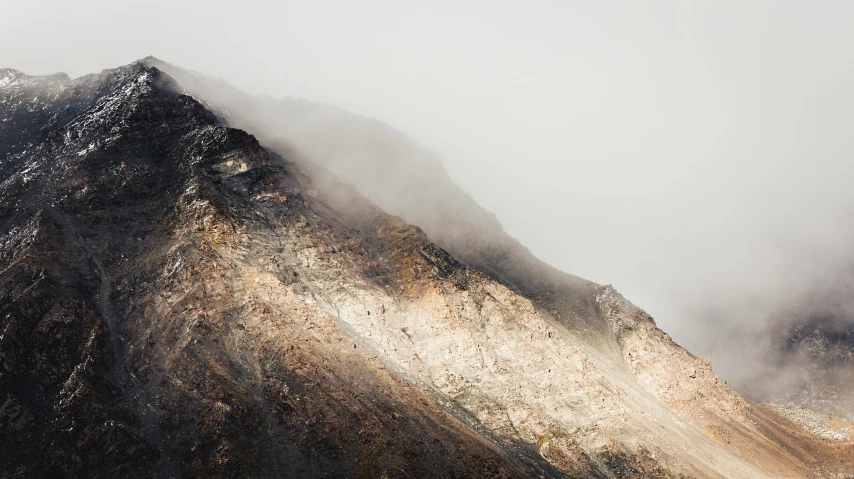 there is a very tall mountain with clouds on top