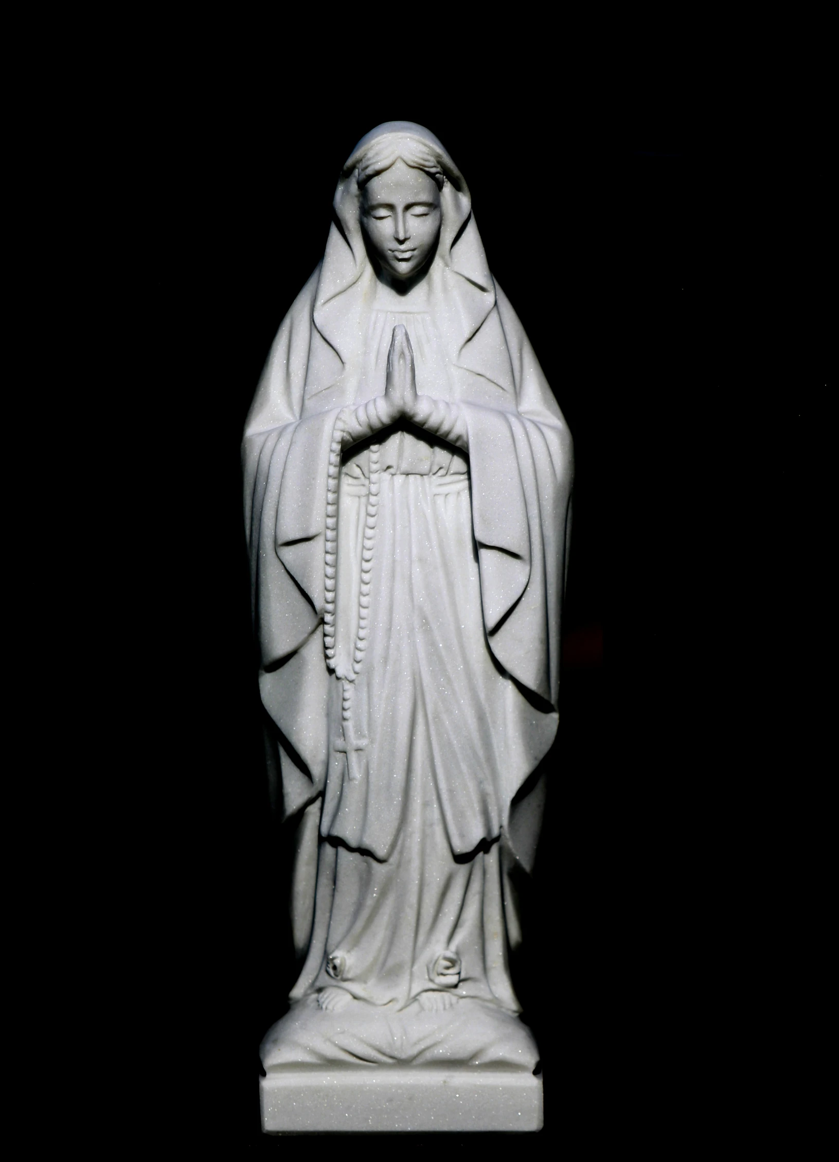 the statue of mary is displayed on a pedestal