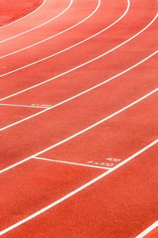 a man walking across a track in the middle of a race