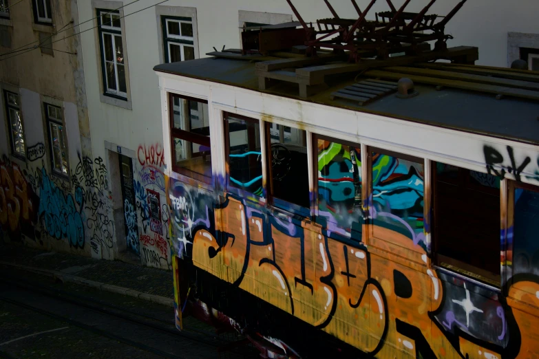 an orange train car covered in graffiti in the city