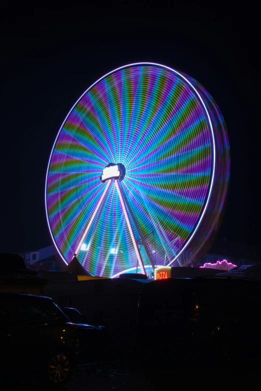 a ferris wheel is lit up with multi - colored lights at night