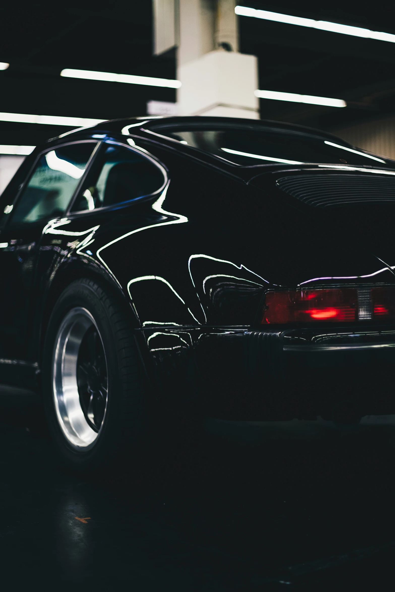 black car parked in a garage near a building