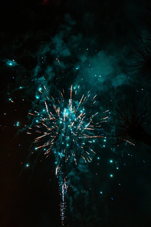 fireworks on a night sky with people looking at it