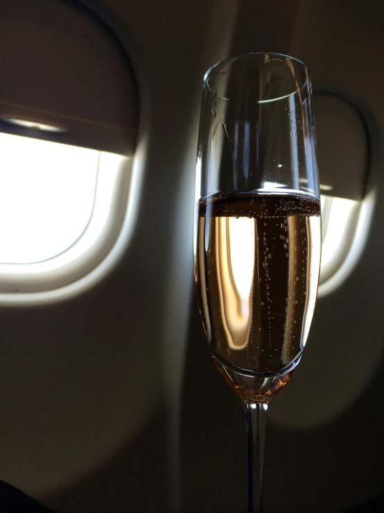 a champagne filled wine glass sitting in front of a window