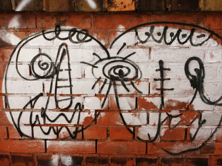 a red brick wall with two white faces