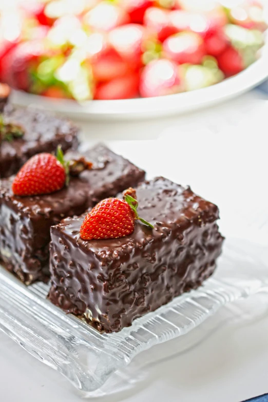 some cake on a tray with strawberries in the background