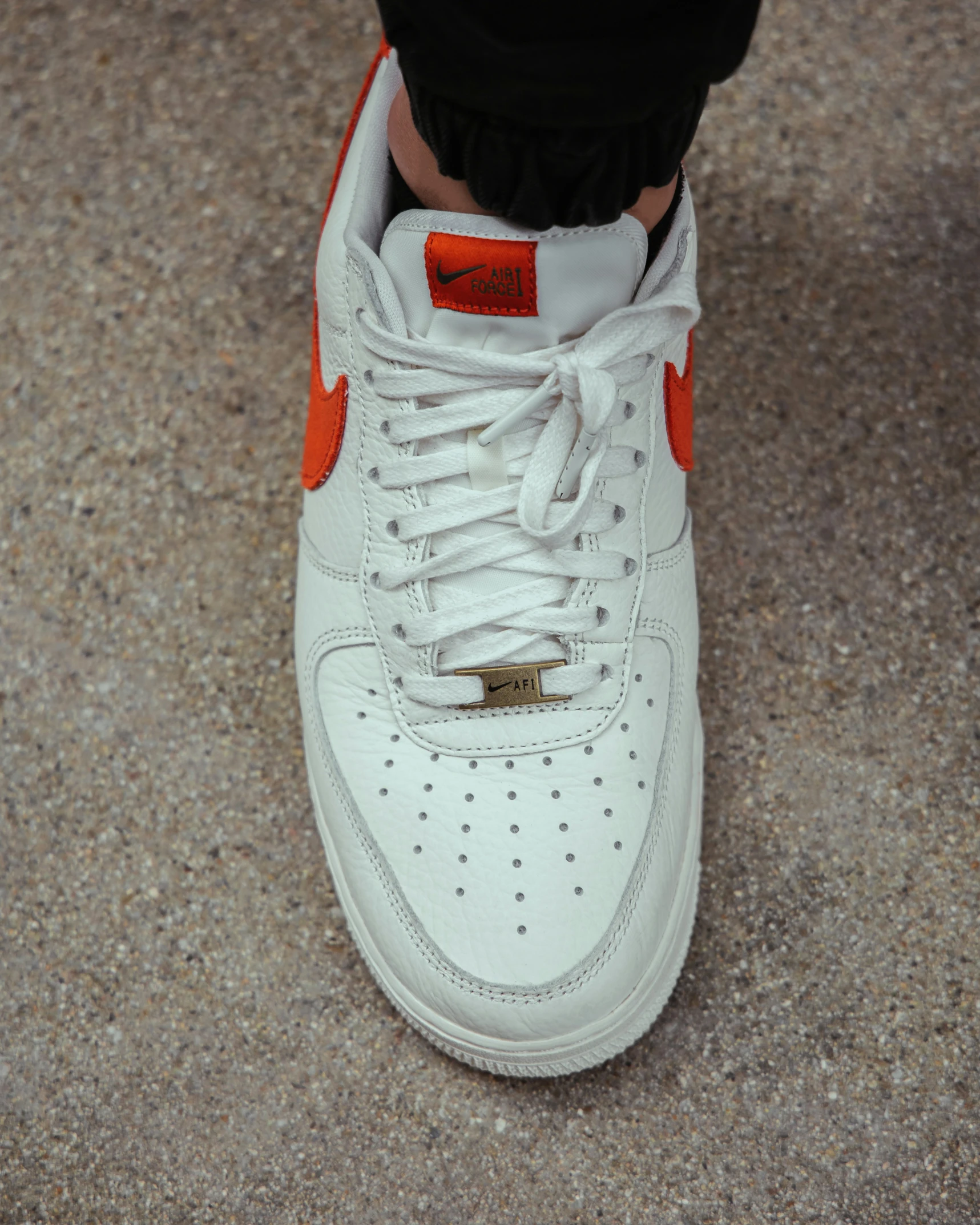 a person's feet in white and orange shoes