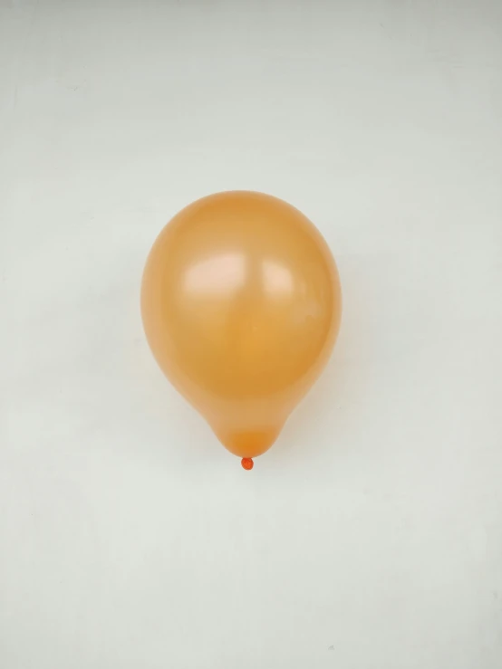 a close up of an orange balloon against a white background