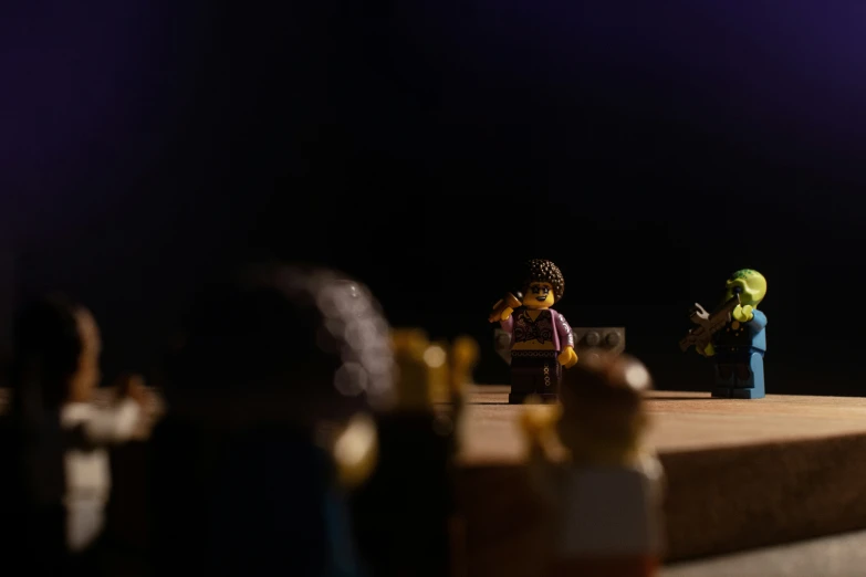 small people with colorfully dressed in legos are standing on a stage