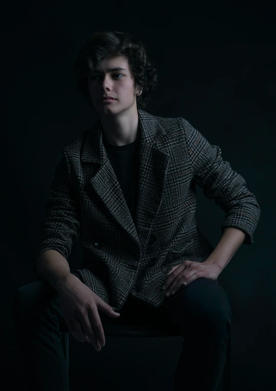 a person sitting on a chair in a dark room