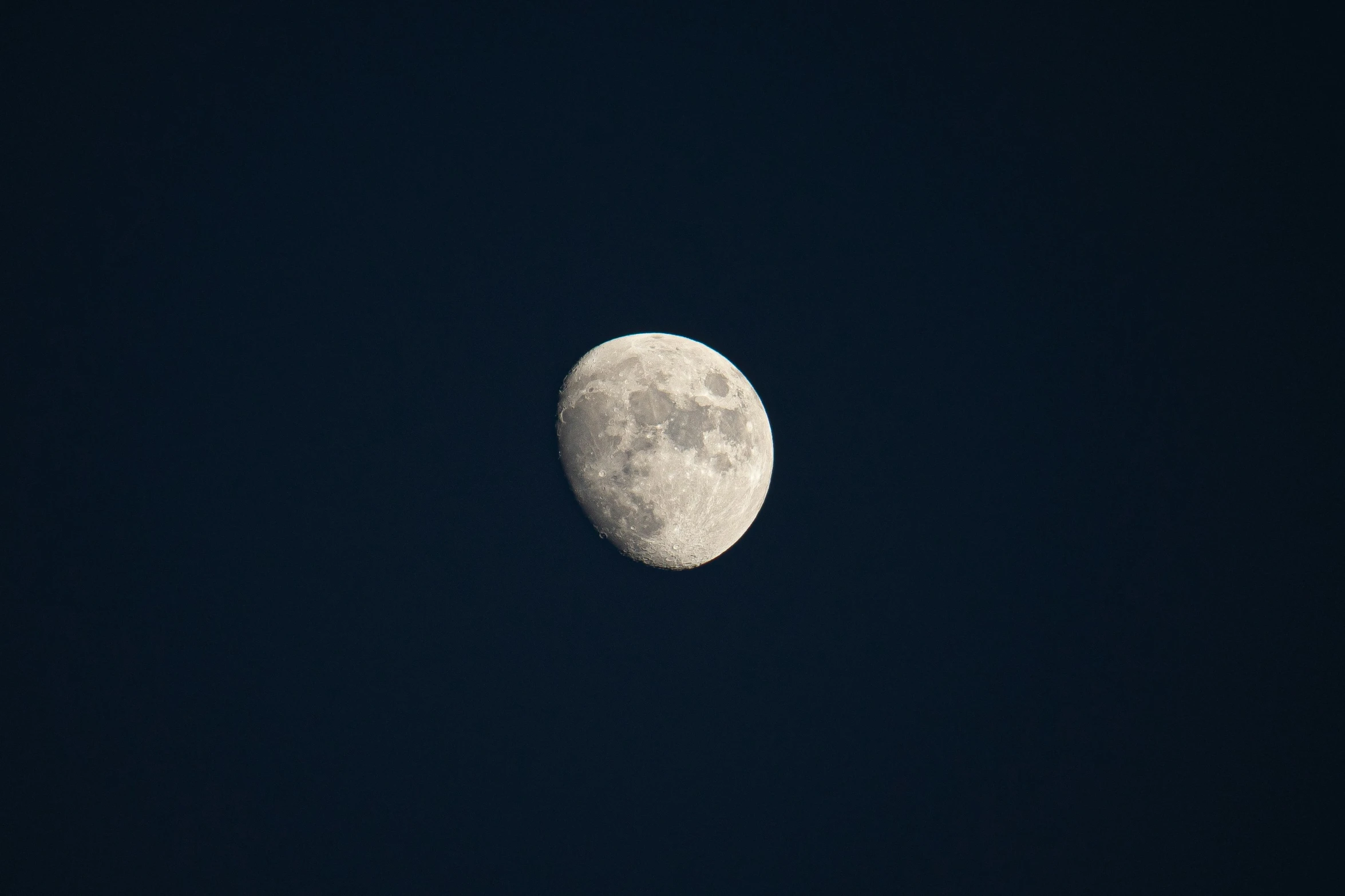 a view of the moon in the dark sky