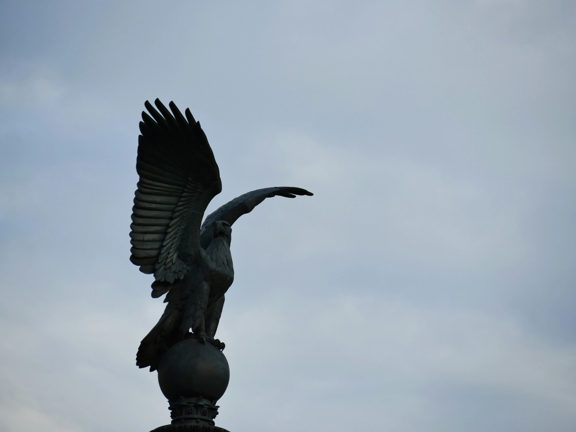 a large bird with it's wings spread out on top of a building