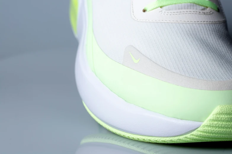 a white sneaker with neon green soles