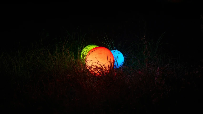 a ball is sitting in the grass at night