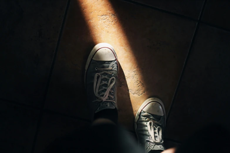 a person stands on the floor in black and white shoes