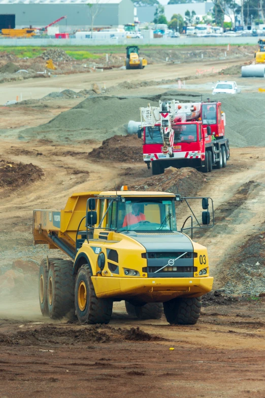 a yellow truck with big wheels is traveling