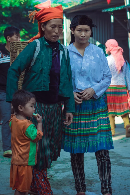 an older woman and two children in colorful outfits