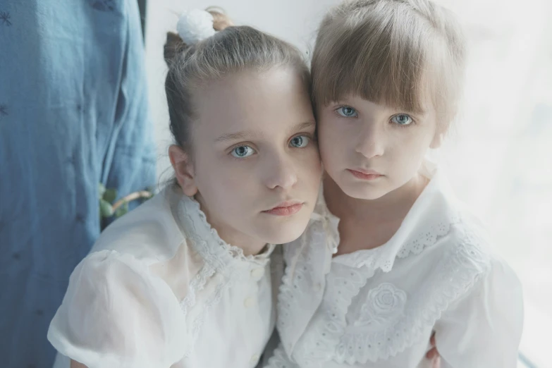 two little girls pose for a po with their hands around each other