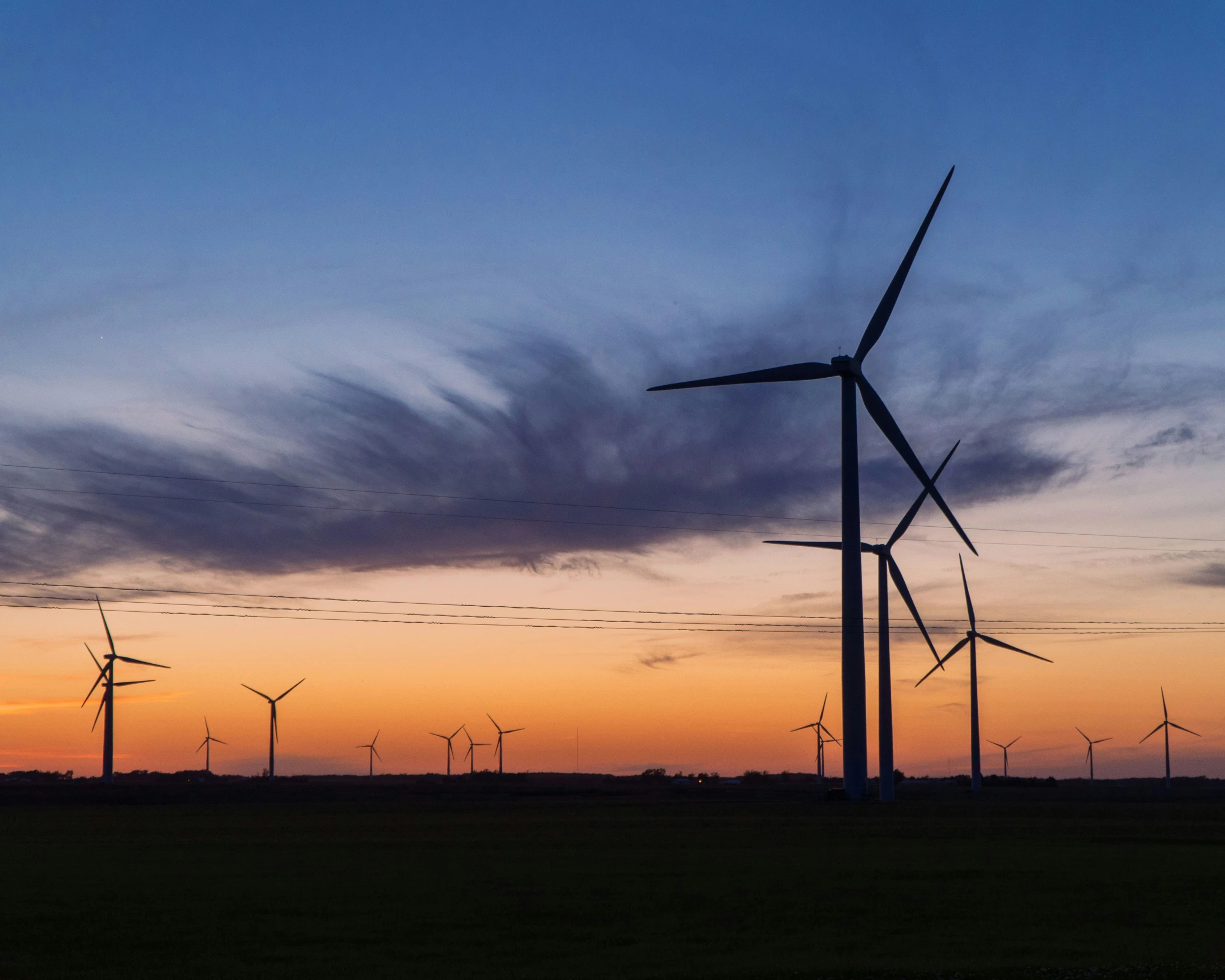 several wind turbine types are shown in the evening