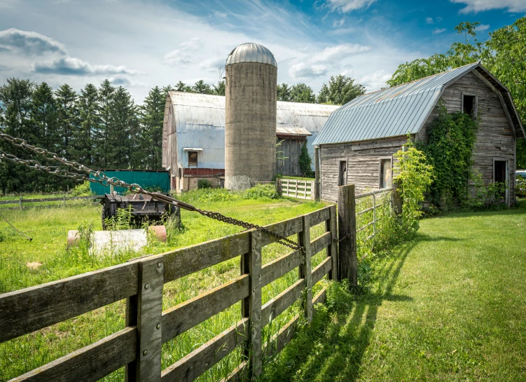 old farm with barn, tractor and grass growing on land