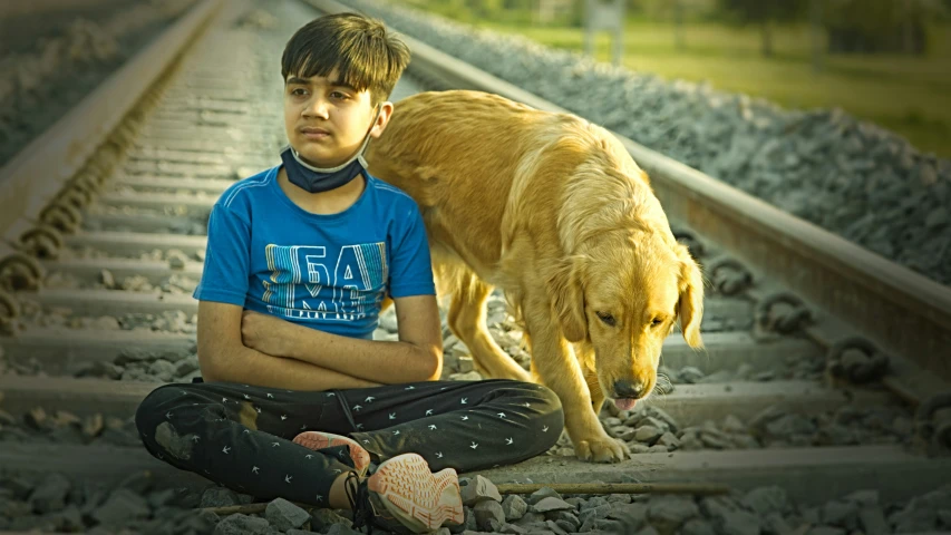 a  sits with his dog on the railroad tracks