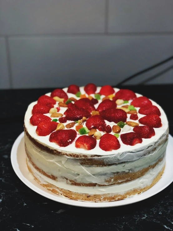 the cake is decorated with white frosting and strawberries on top