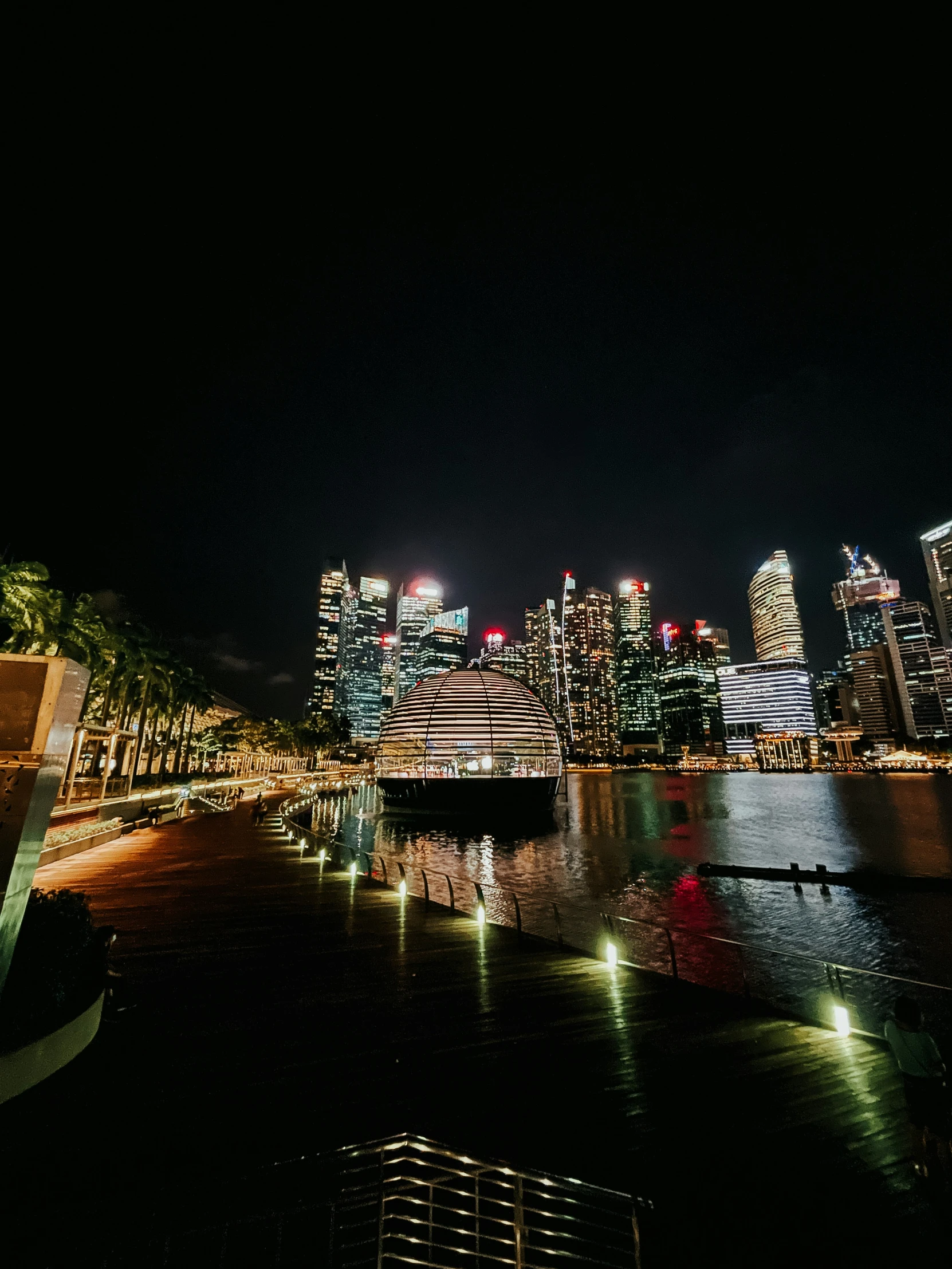 there is a city skyline at night with lights reflecting off the water