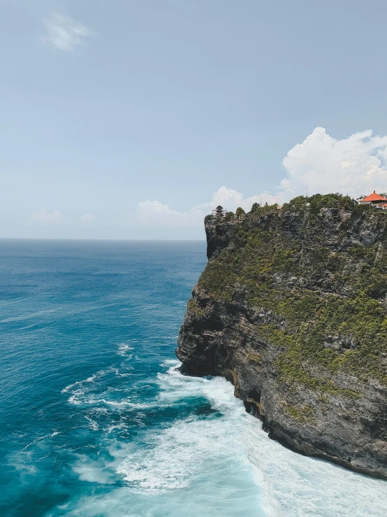 a man standing on top of a cliff near the ocean