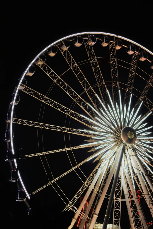 a ferris wheel sitting next to a street light at night