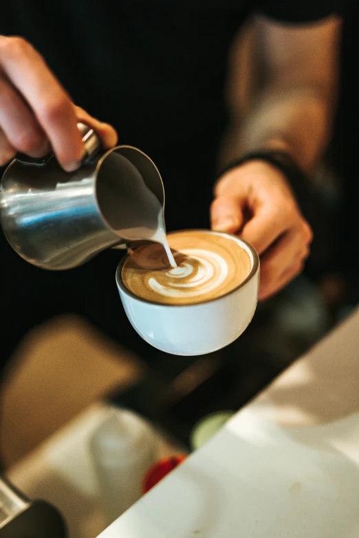 a cup of coffee being poured into it