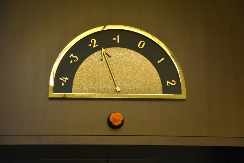 a clock mounted on the side of a wall with an orange bell