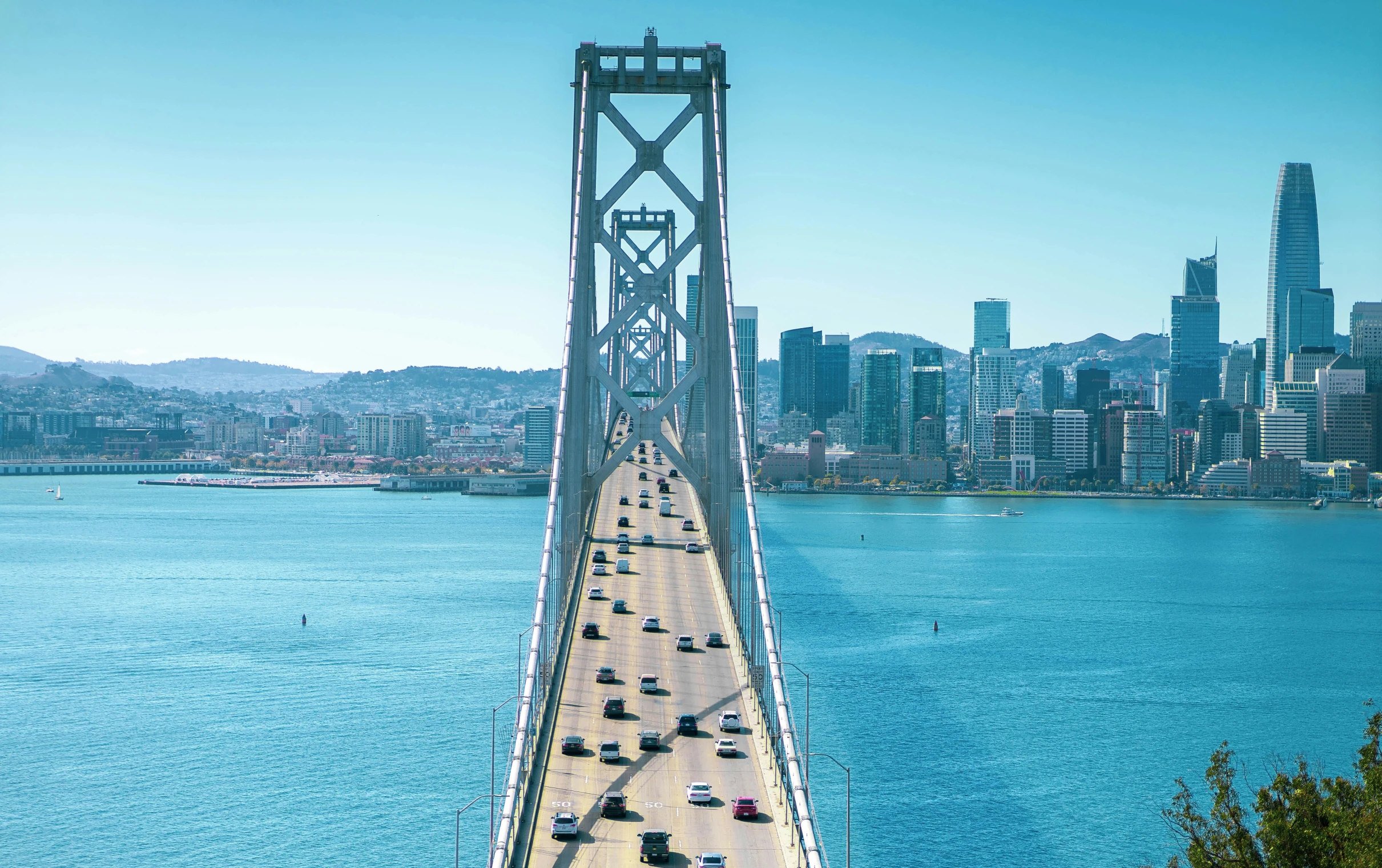 cars are driving over the bridge on a lake