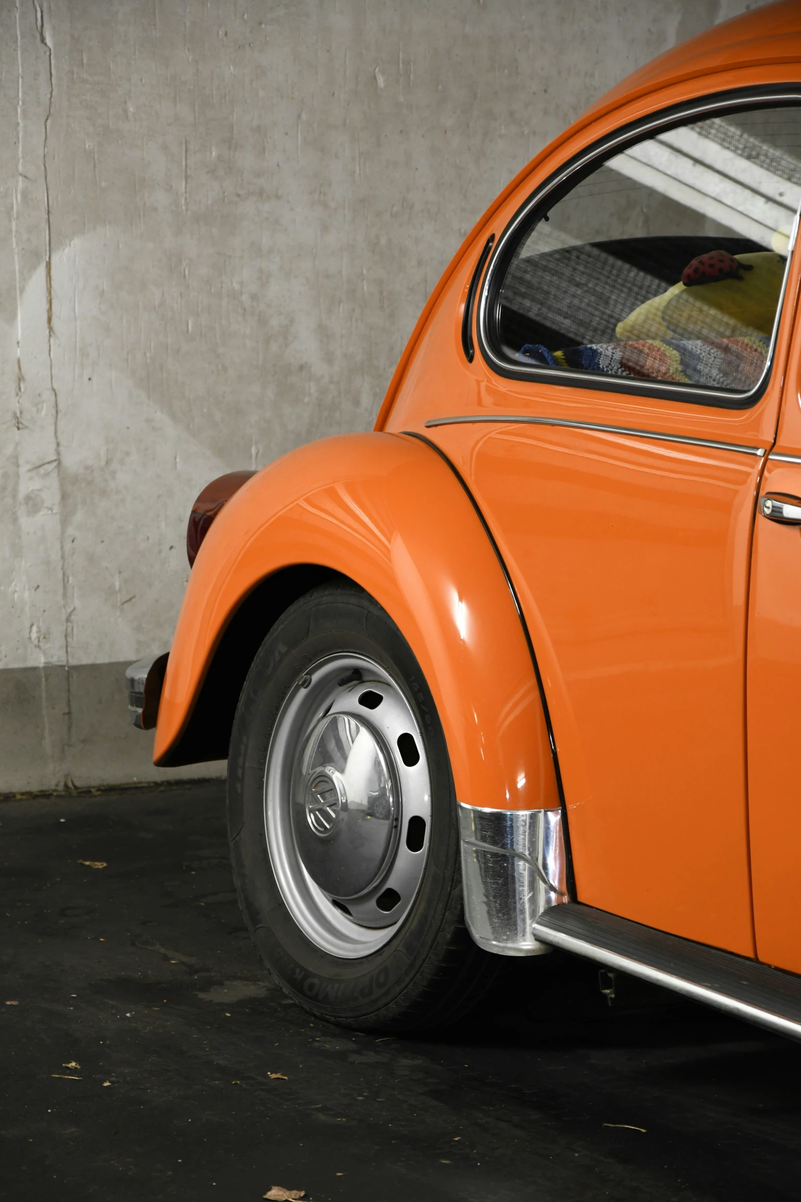 orange and silver car parked in garage area next to wall