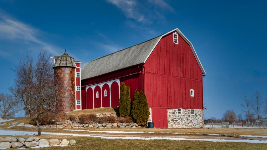 there is a red barn with a brick chimney and window