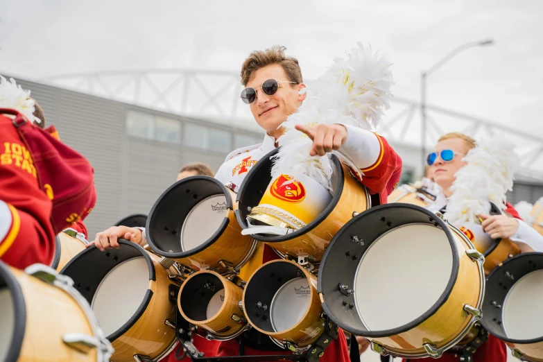 a band wearing uniforms playing on wooden drums