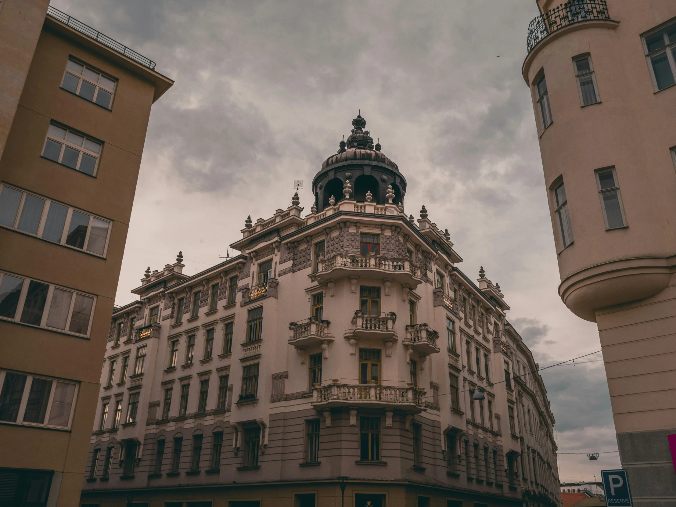 tall buildings with steeples and ornate detailing line the corner of a street